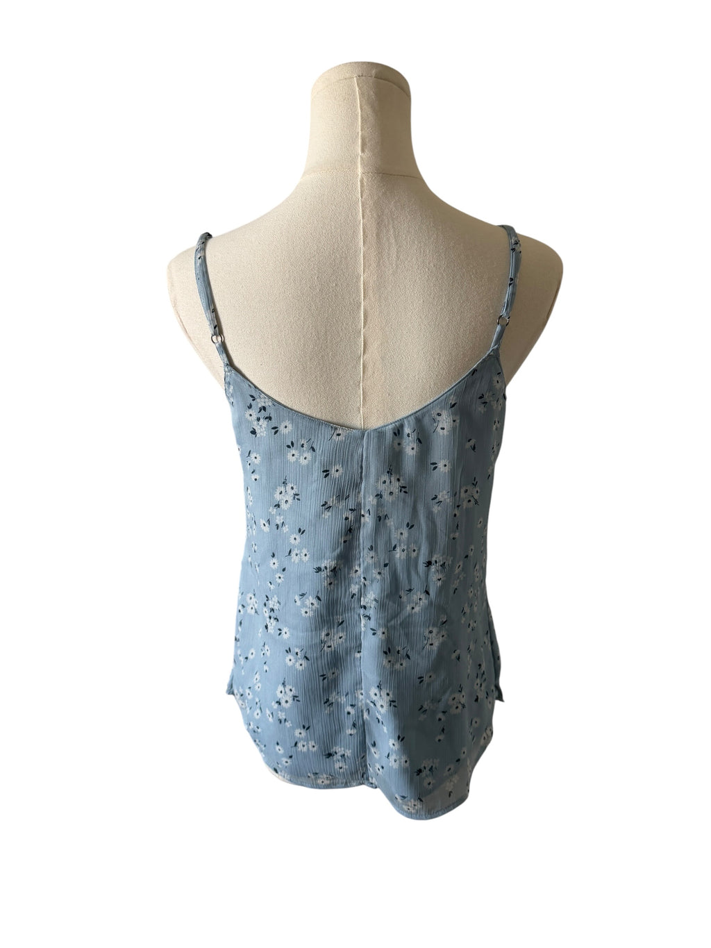 Blue floral sleeveless top on a mannequin against a white background