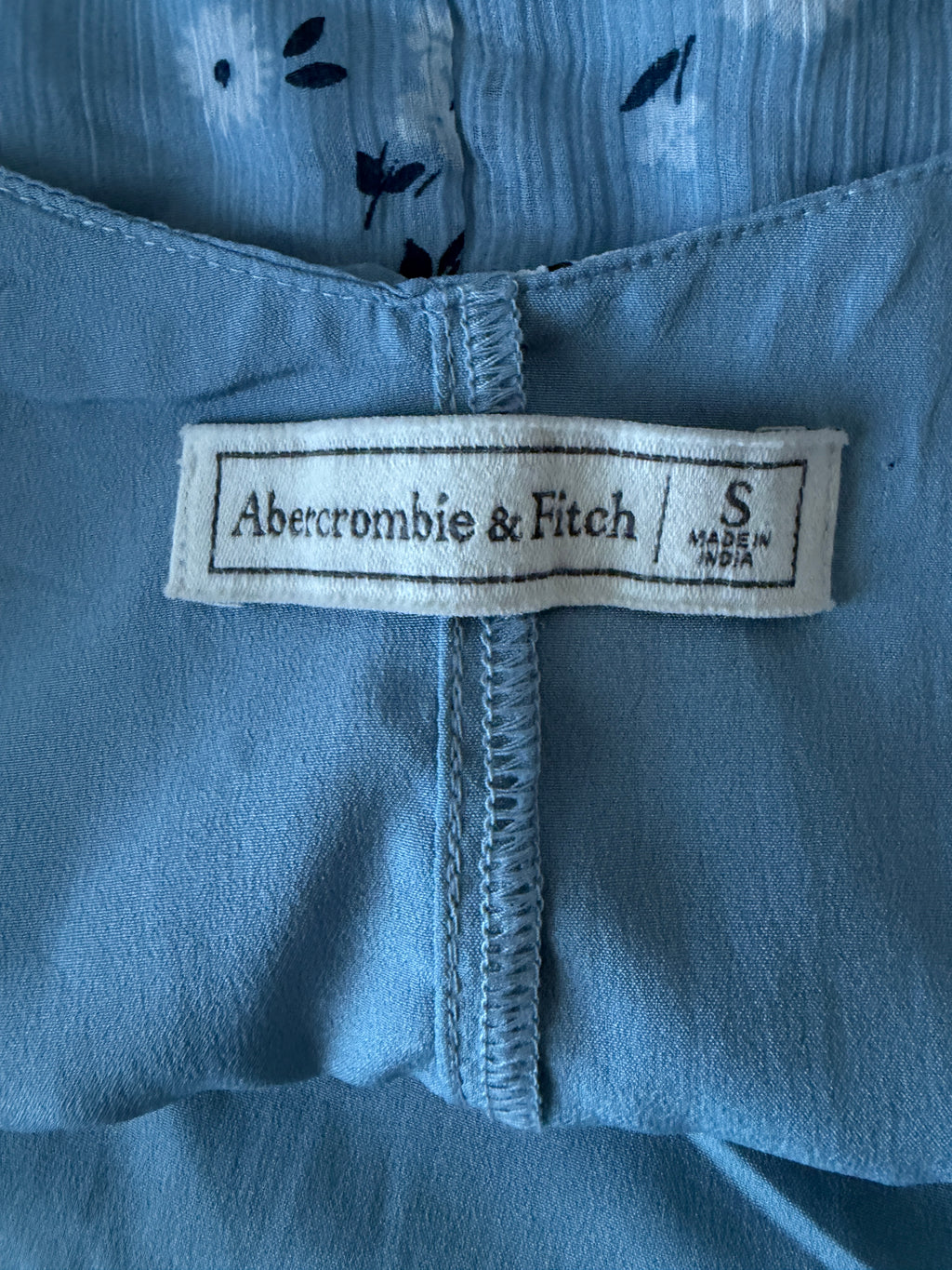 Close-up of an Abercrombie & Fitch label on a blue garment.