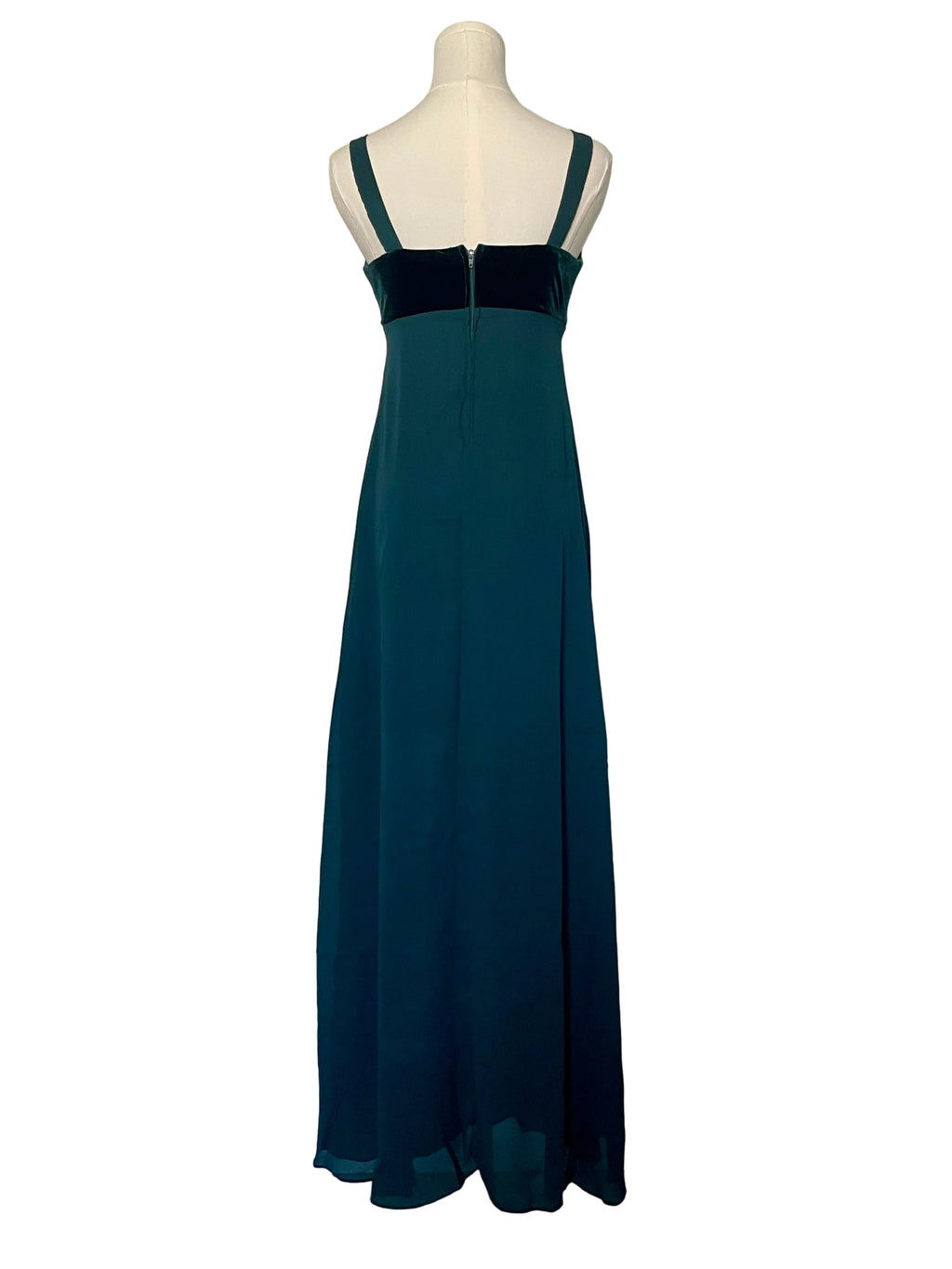 Teal dress on a mannequin against a white door.