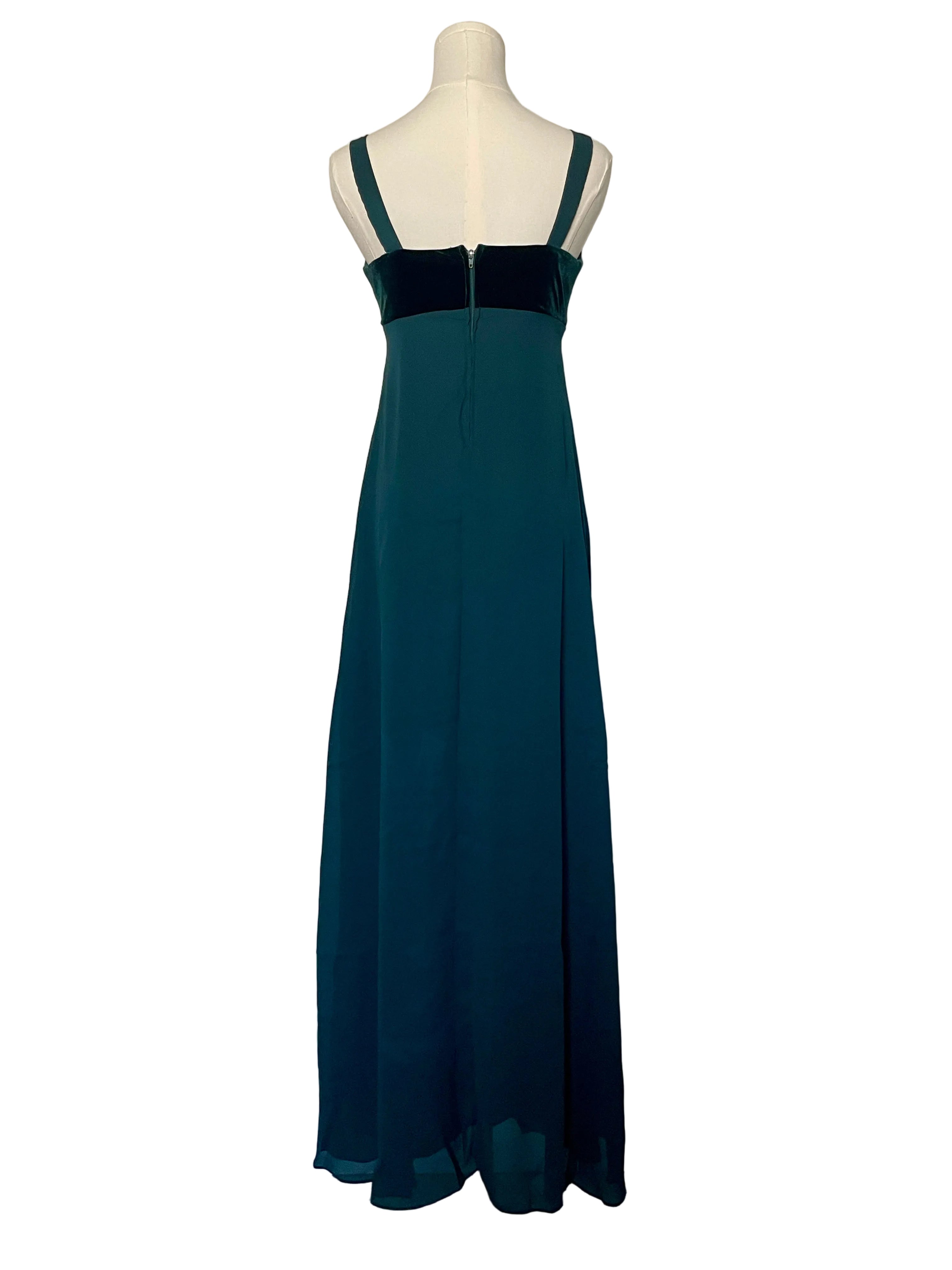 Teal dress on a mannequin against a white door.
