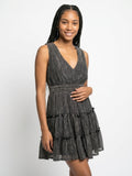 Woman wearing a black tiered dress on a white background