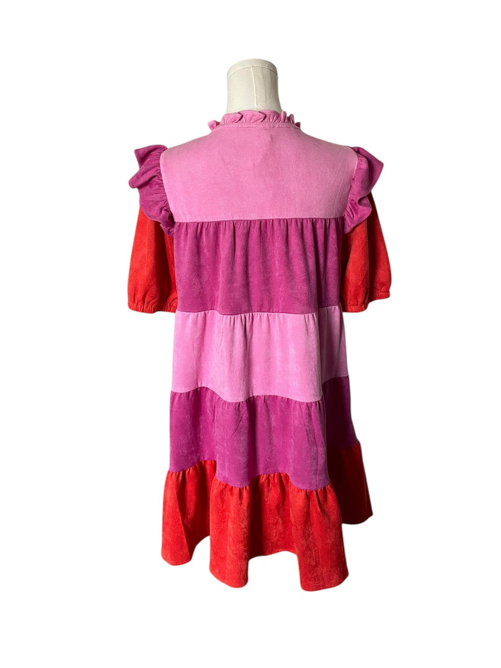 Pink and red dress on a mannequin against a white background