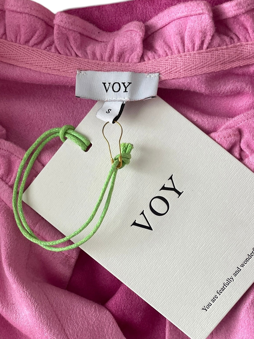 Green bracelet on aVOY branded card with pink fabric background
