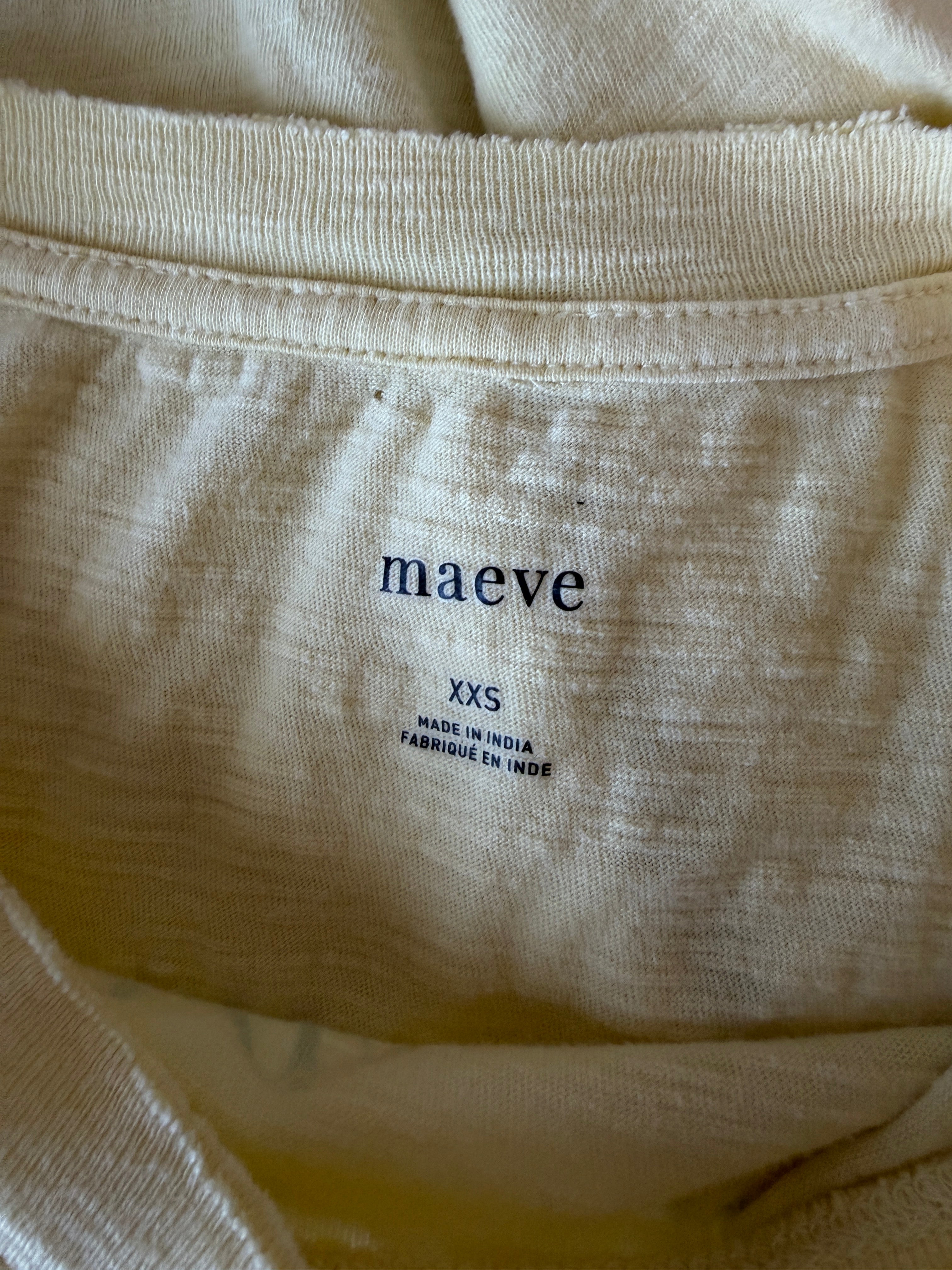 Close-up of beige fabric with 'maéve' label on a plain background