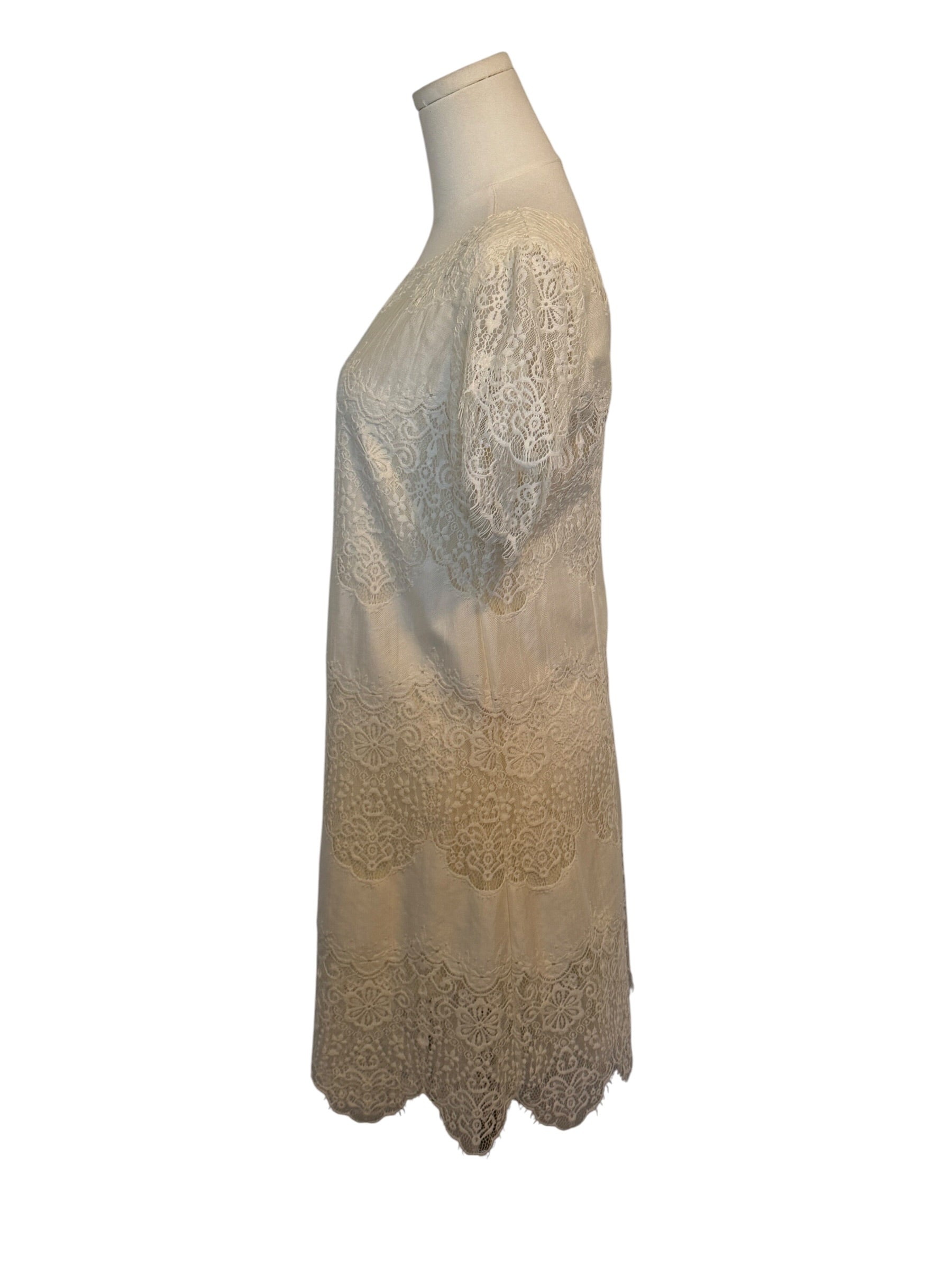 Beige lace dress on a mannequin against a white background