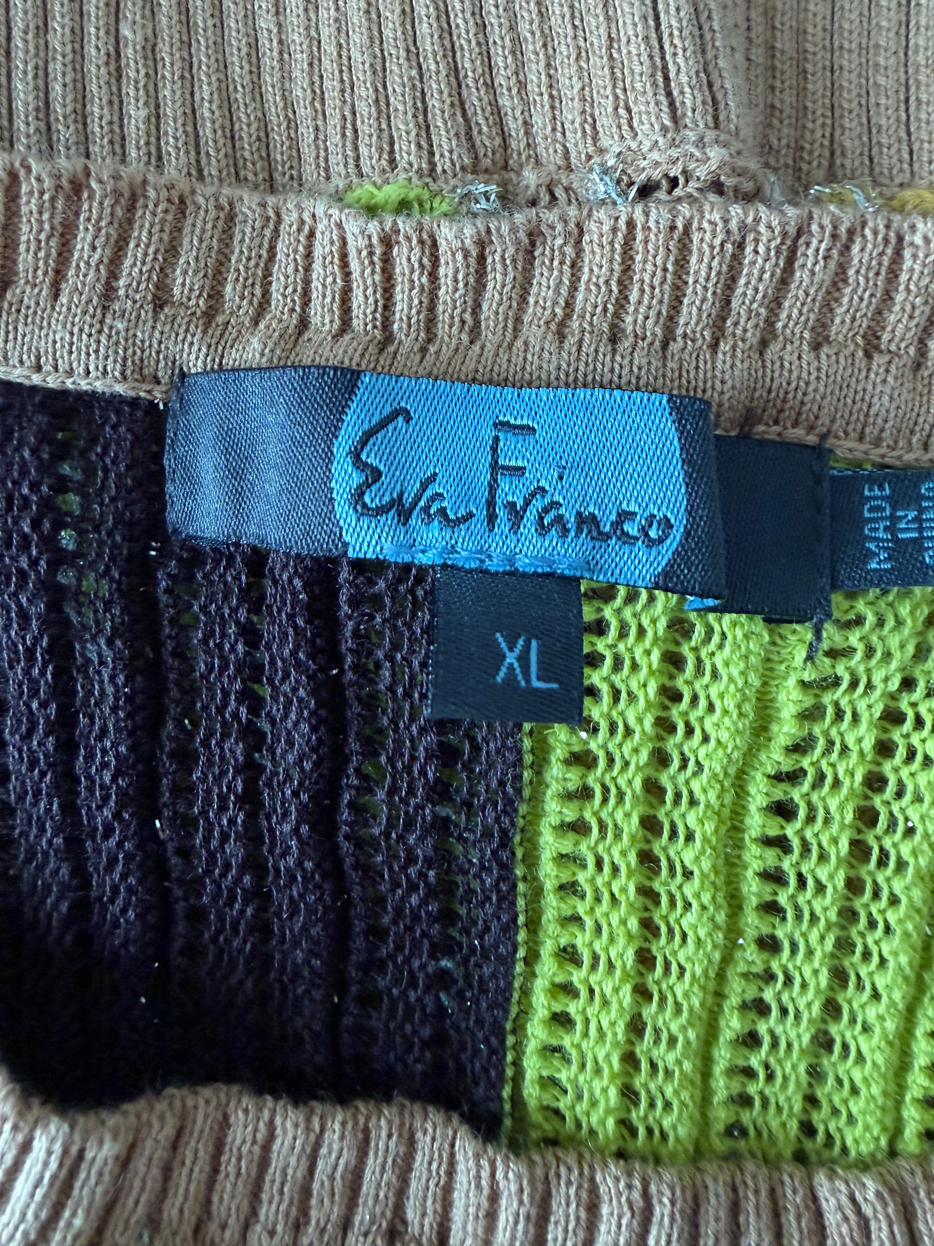 Close-up of a clothing tag with 'Sara Franco' branding on a multicolored fabric background.