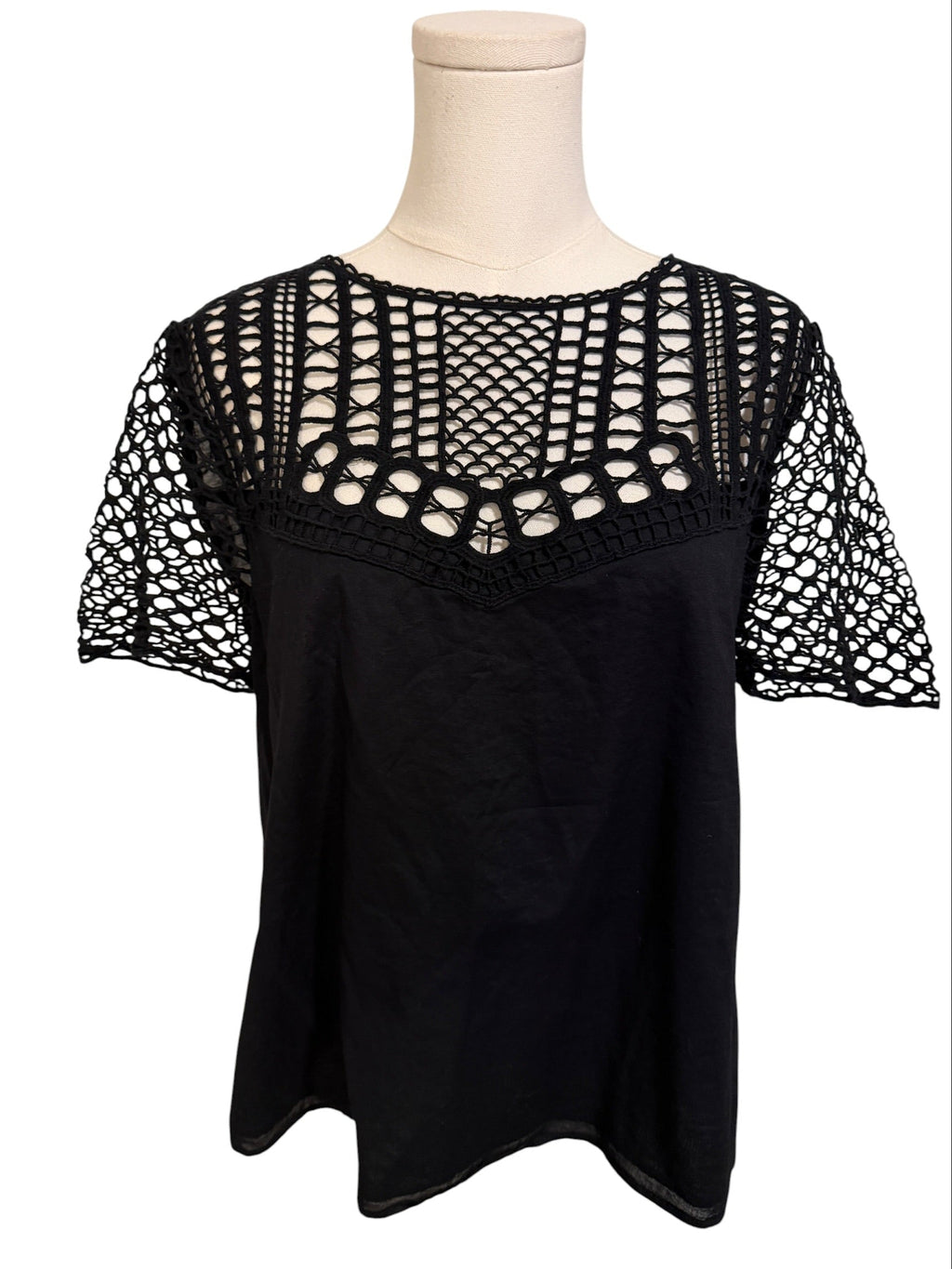 Black top with crochet sleeves on a mannequin against a white background