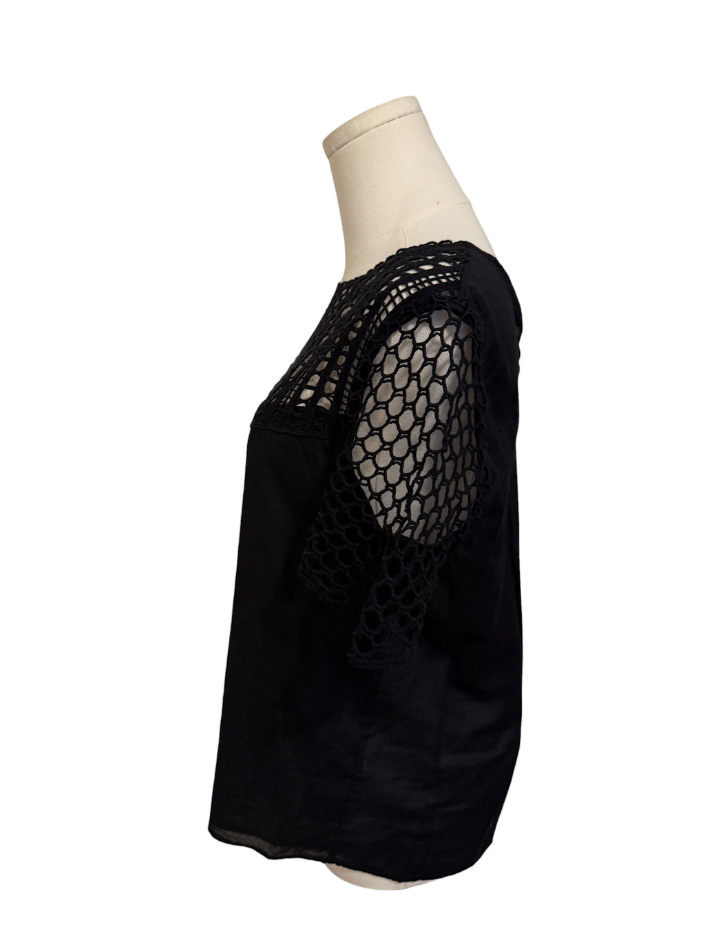 Black mesh top on a mannequin against a white background