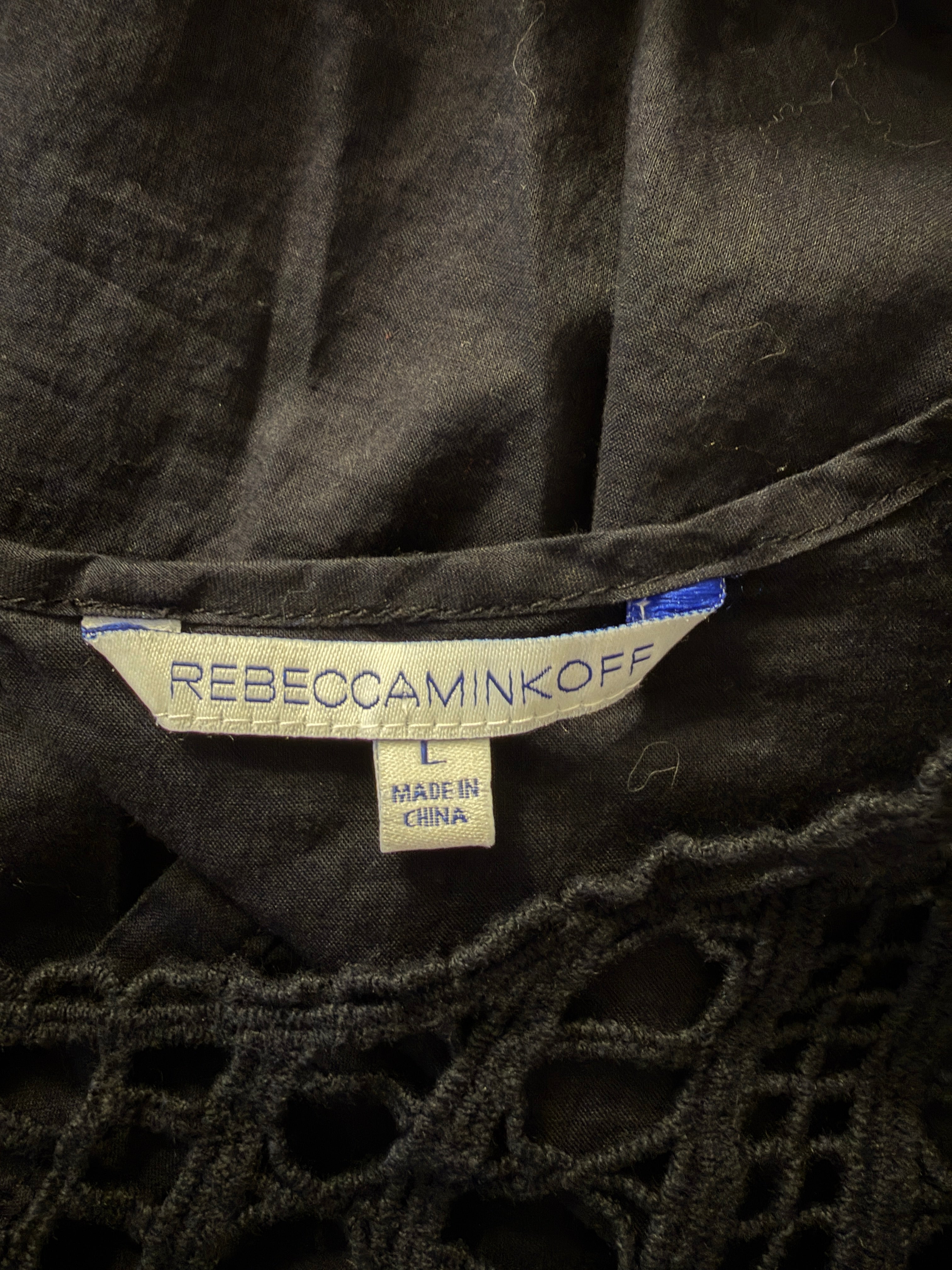 Rebecca Minkoff label on a black garment with intricate lace details.