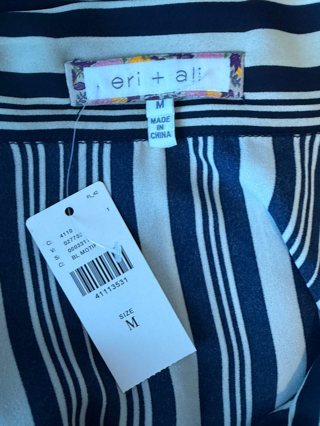 Navy and white striped shirt with a tag and size label on a blue background