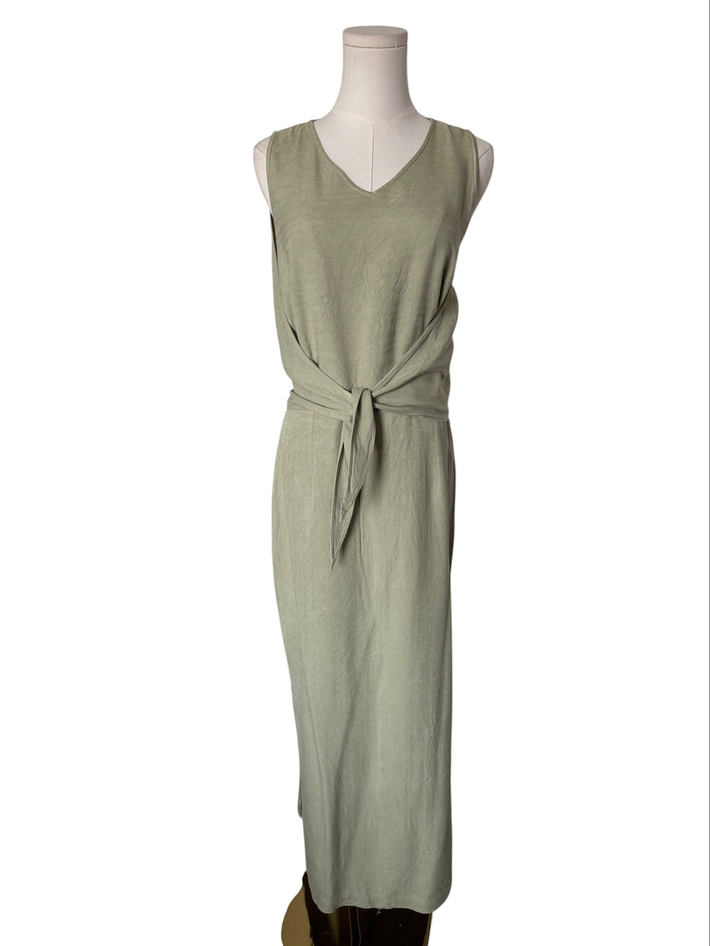 Green dress on a mannequin against a white background