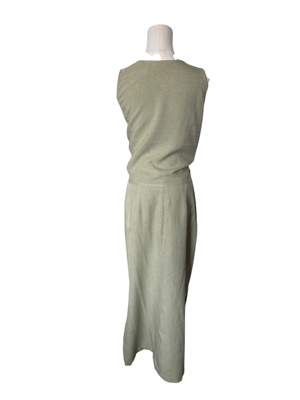 Green dress on a mannequin against a white background