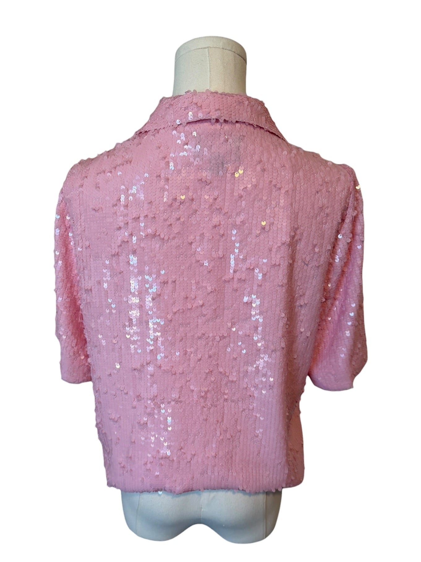 Pink sequined jacket on a mannequin against a white background