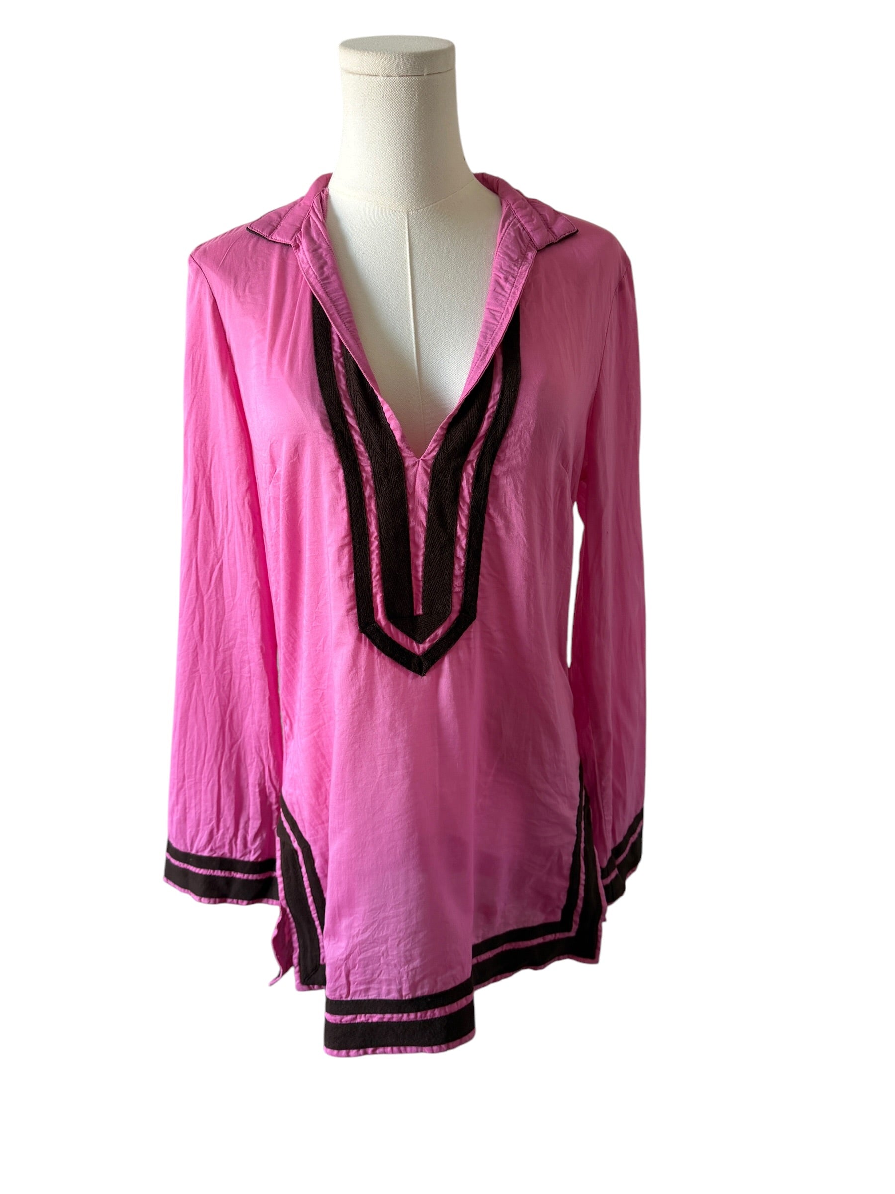 Pink blouse with black accents on a mannequin against a white background