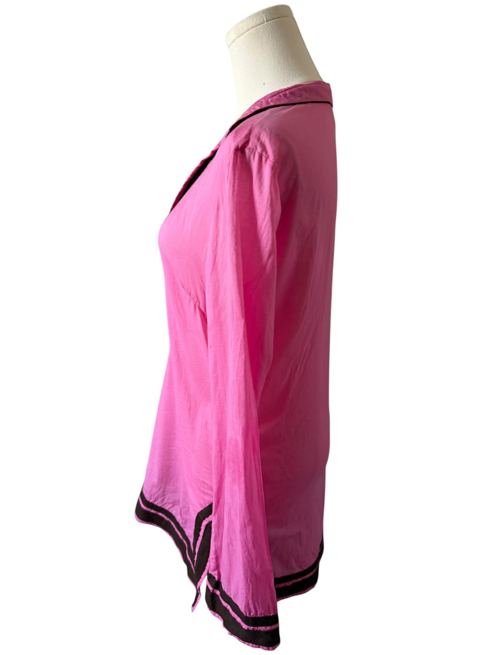 Pink top with black trim on a mannequin against a white background