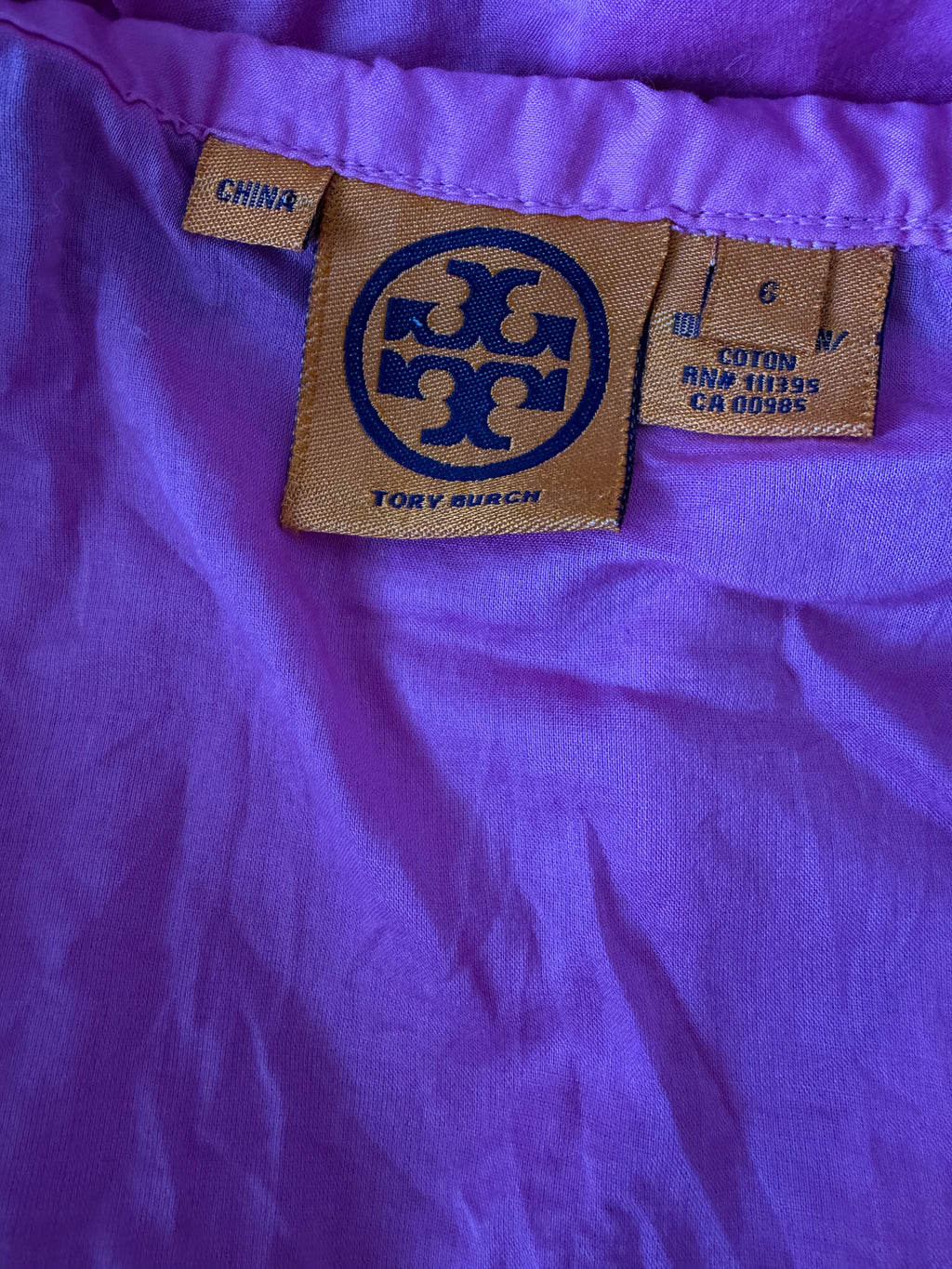 Close-up of a purple fabric with a Tory Burch label.