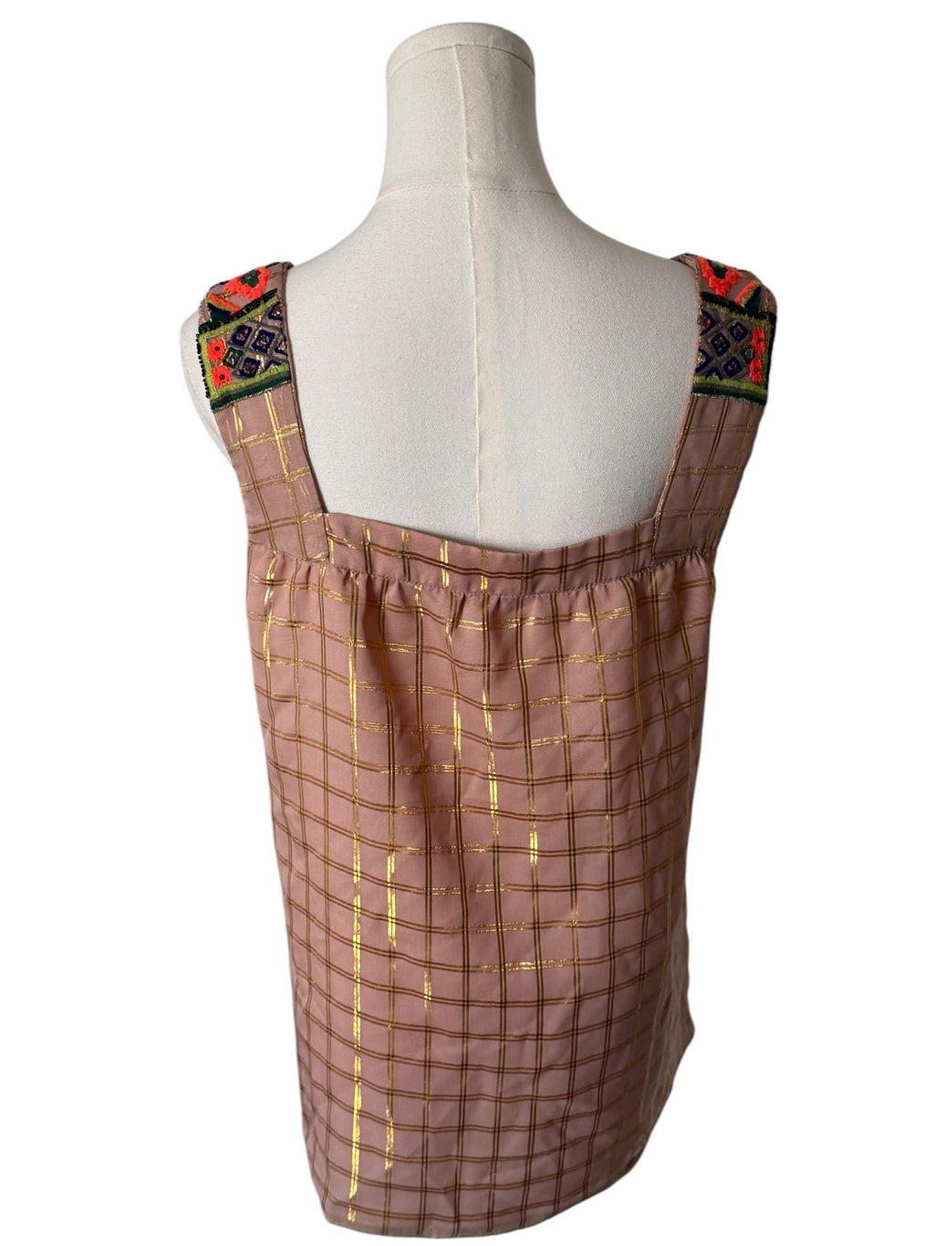 Mannequin wearing a brown checkered dress with colorful embroidery on a white background