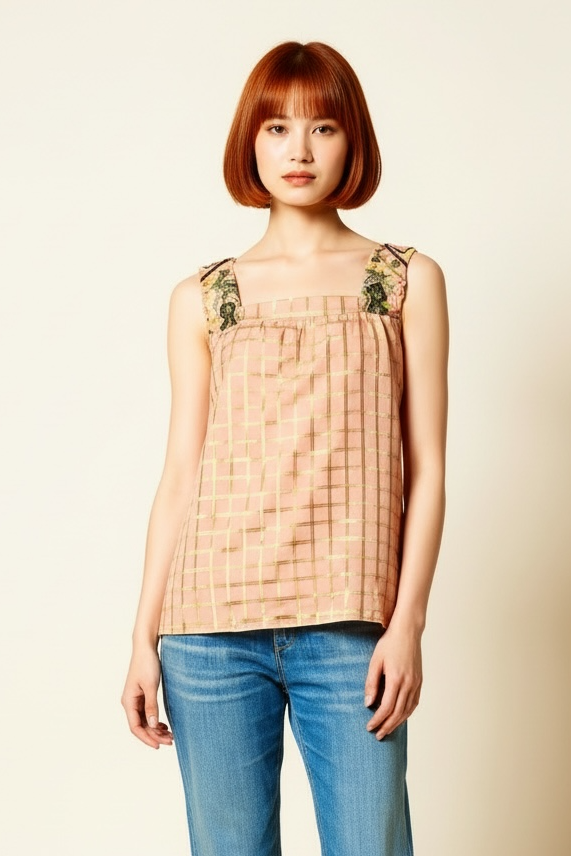 Woman wearing a beige checkered top and blue jeans on a beige background